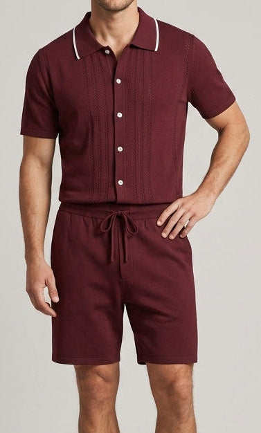 Man wearing a maroon outfit with white trim on a plain background