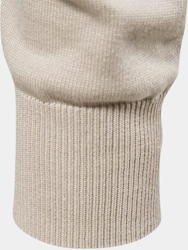 Close-up of a beige knitted sweater on a white background