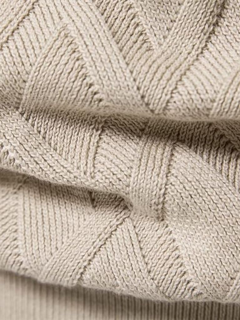 Close-up of beige knitted fabric with a geometric pattern