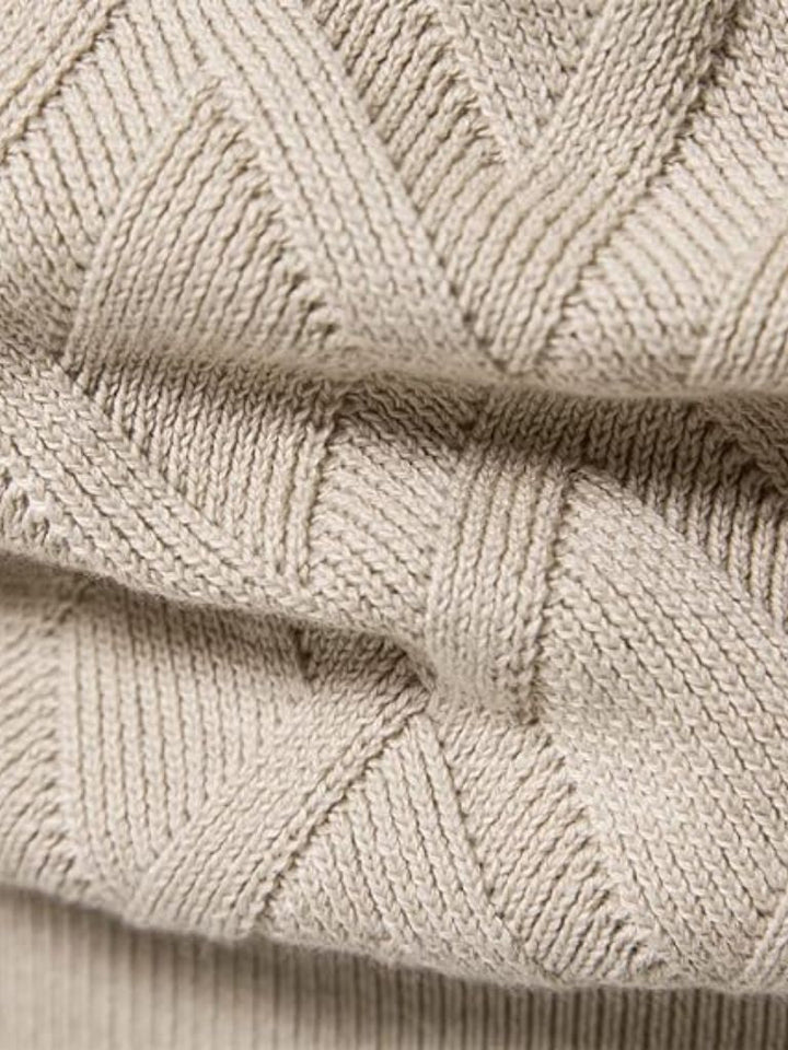 Close-up of beige knitted fabric with a geometric pattern